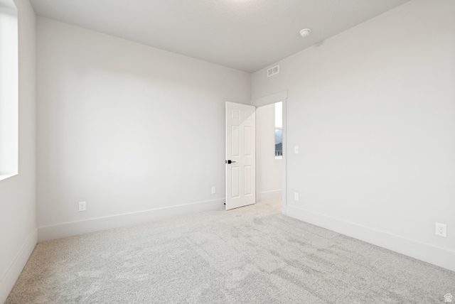 529 North Hvn Drive Mapleton, UT 84664 - Photo 25 of 30 Neutral wall color with plush carpet flooring, showcasing a white interior door with black hardware, white trim, and a window providing natural light