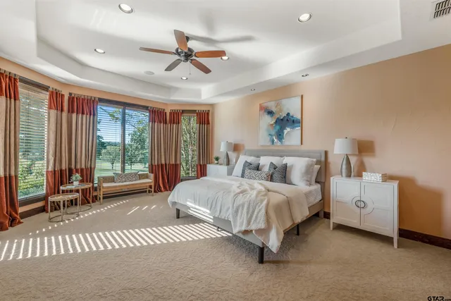 a spacious bedroom with a bed and large windows