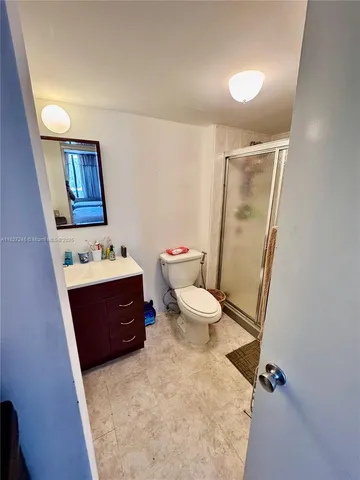 a bathroom with a sink vanity mirror and toilet