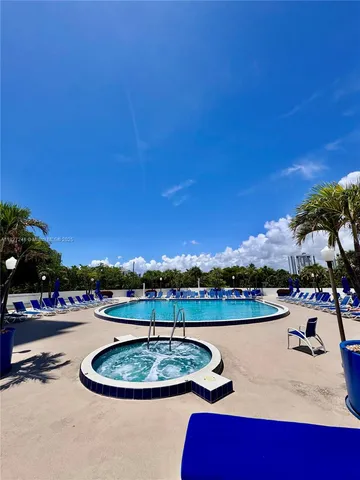 a view of a swimming pool with outdoor seating and plants