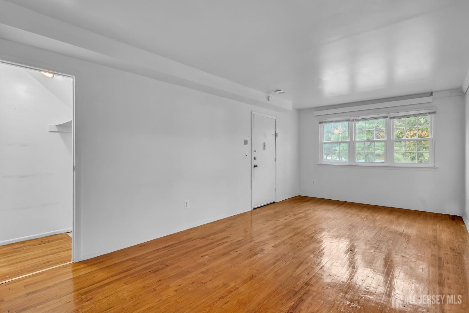 14 College Drive Edison, NJ 08817 - Photo 11 of 22 an empty room with wooden floor and windows