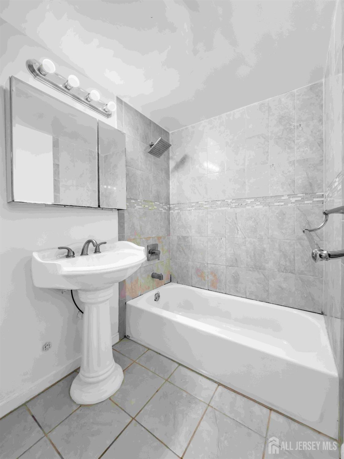 14 College Drive Edison, NJ 08817 - Photo 22 of 22 a bathroom with a sink a mirror and a bathtub