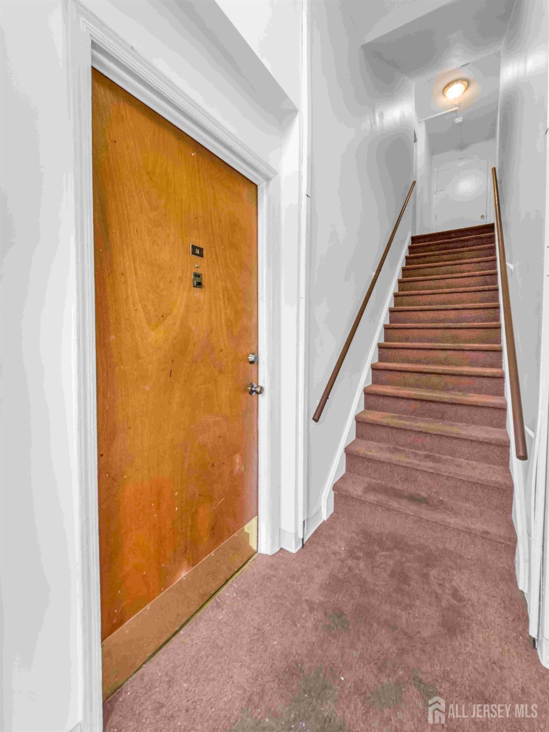 14 College Drive Edison, NJ 08817 - Photo 7 of 22 a view of a hallway with wooden floor and staircase