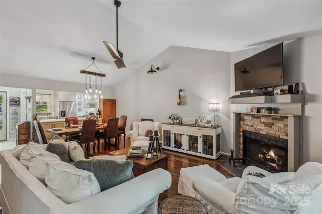 a living room with furniture a flat screen tv and a fireplace