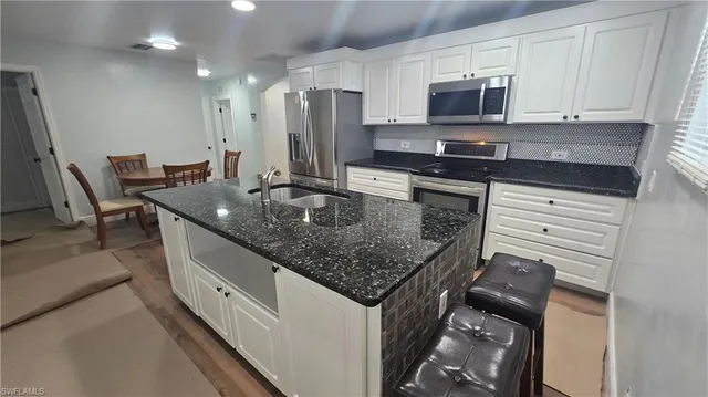a kitchen with stainless steel appliances granite countertop a sink stove and microwave