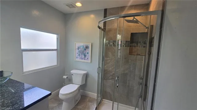 a bathroom with a granite countertop sink toilet and shower