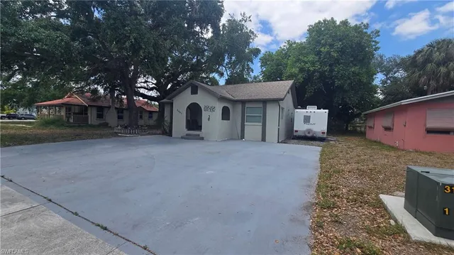 a view of a house with a yard and large tree
