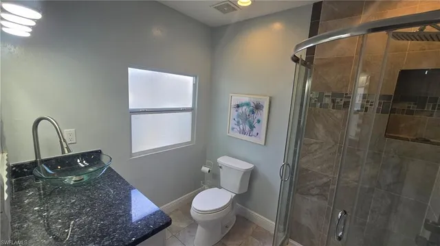 a bathroom with a granite countertop sink and shower