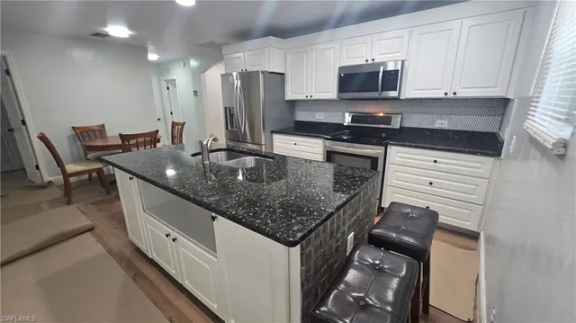a kitchen with stainless steel appliances granite countertop a sink stove and refrigerator