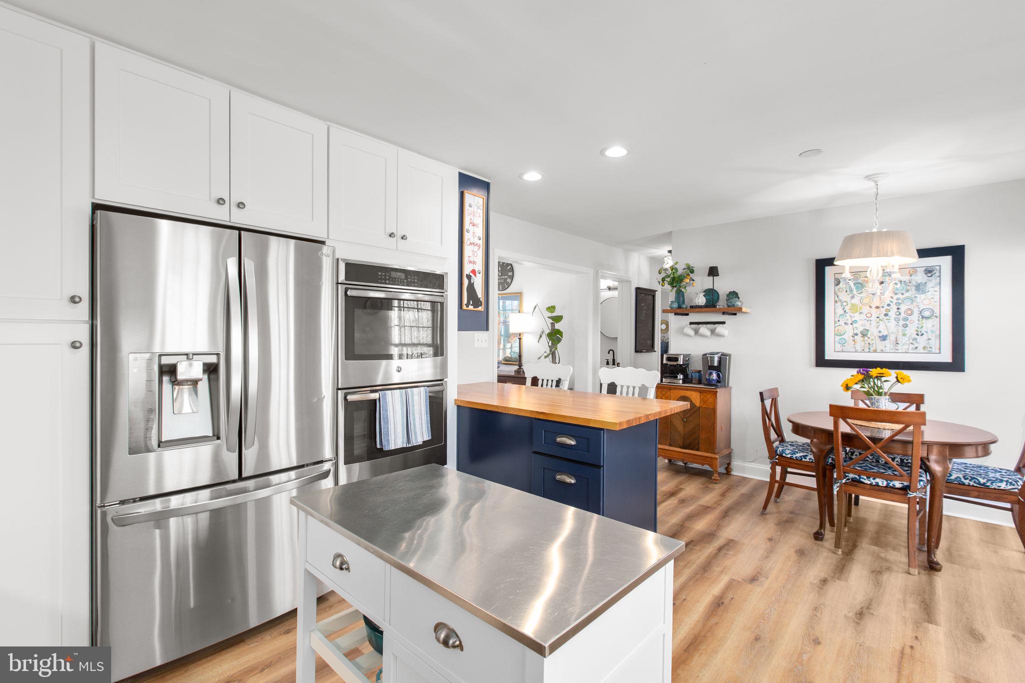 28896 Horseshoe Road Culpeper, VA 22701 - Photo 23 of 36 a kitchen with stainless steel appliances a refrigerator a stove a dining table and chairs with wooden floor