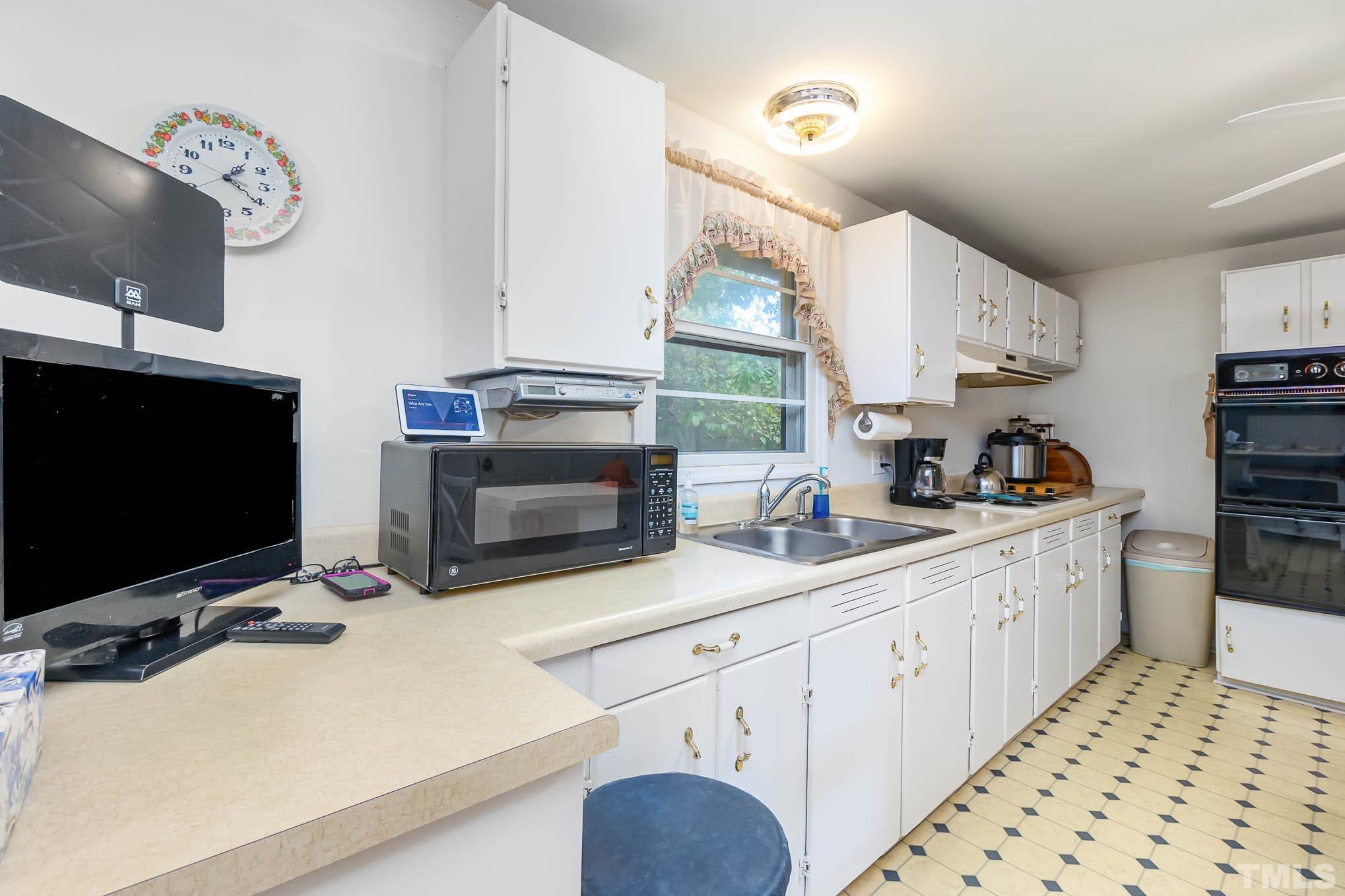 1921 Ebenezer Church Road Coats, NC 27521 - Photo 11 of 24 a kitchen with stainless steel appliances a stove a sink and a microwave