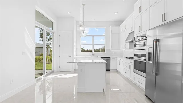 a kitchen with stainless steel appliances a white cabinets and a window