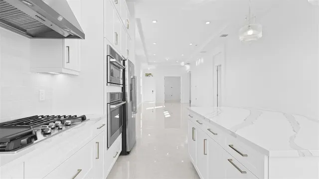a kitchen with granite countertop a sink stove and refrigerator