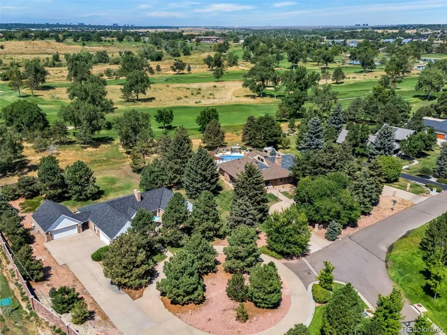 an aerial view of residential houses with outdoor space and trees
