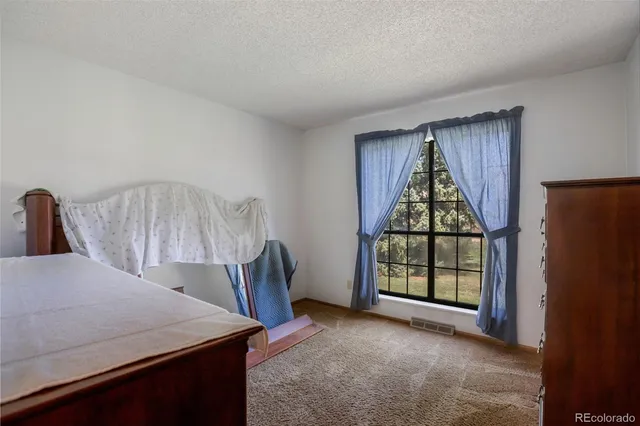 a view of a bedroom with furniture and window