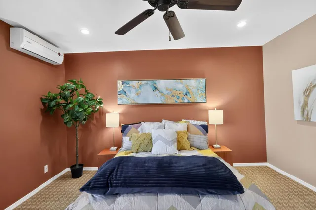 a bed sitting in a room next to a lamp