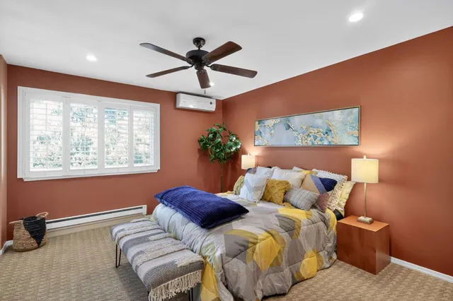 a bedroom with a bed and a painting on the wall