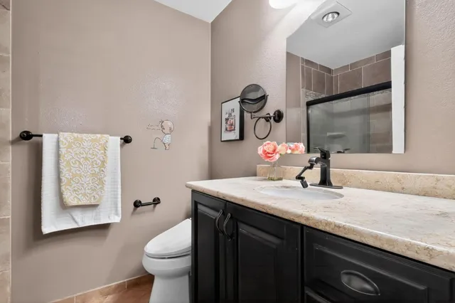 a bathroom with a granite countertop sink toilet and a mirror
