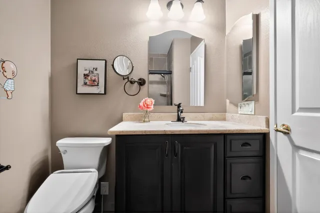 a bathroom with a toilet a sink and a mirror