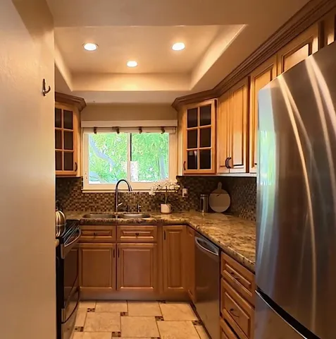 a kitchen with stainless steel appliances granite countertop sink stove and refrigerator