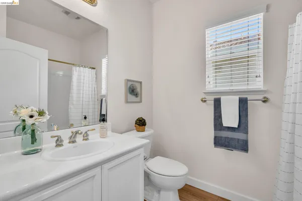 a bathroom with a granite countertop sink toilet and mirror