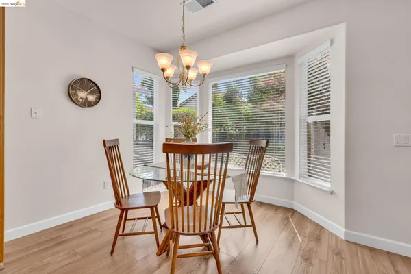 a view of a dining room with furniture a chandelier and wooden floor