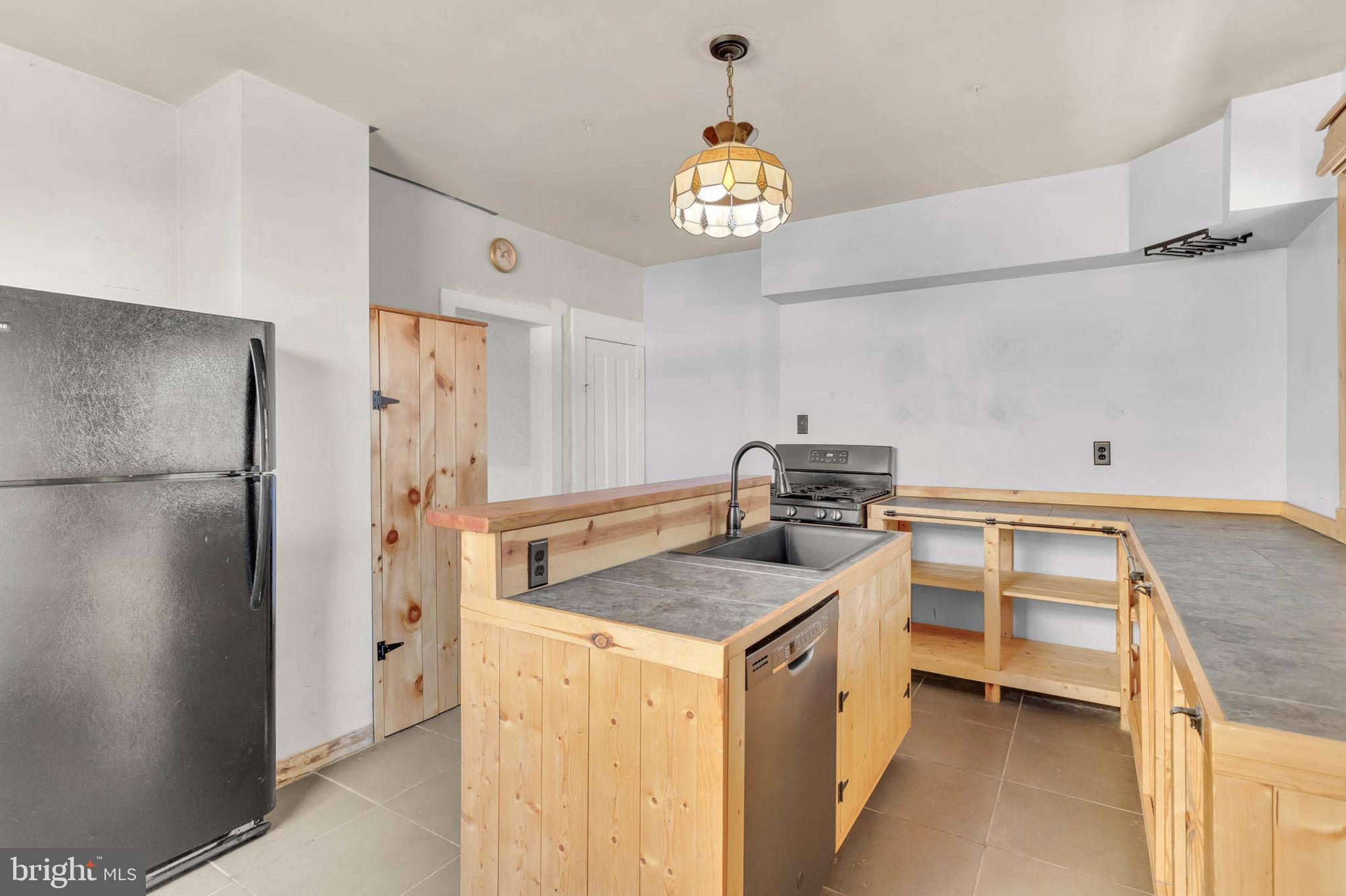 3724 5th Street Baltimore, MD 21225 - Photo 11 of 30 a kitchen with stainless steel appliances granite countertop a refrigerator a stove and a sink