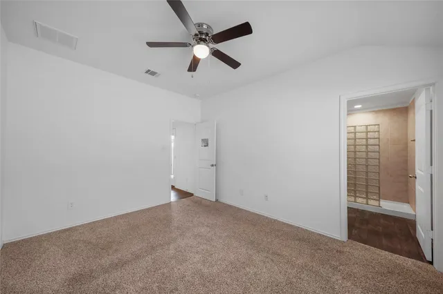 en empty room with ceiling fan and window