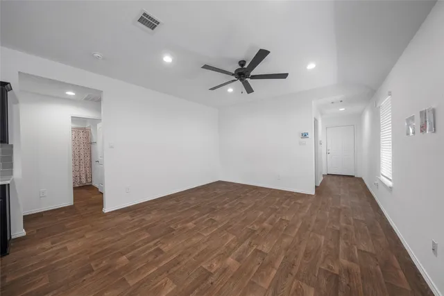 a view of empty room with wooden floor