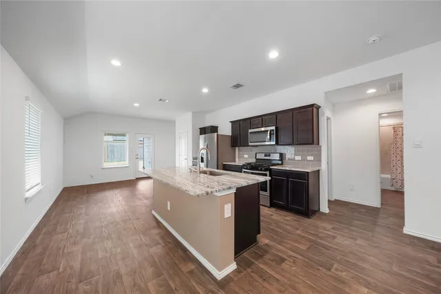 a large kitchen with stainless steel appliances granite countertop a large center island and a sink