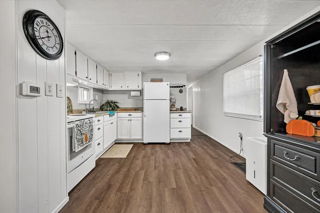 a kitchen with a refrigerator a stove top oven and a sink