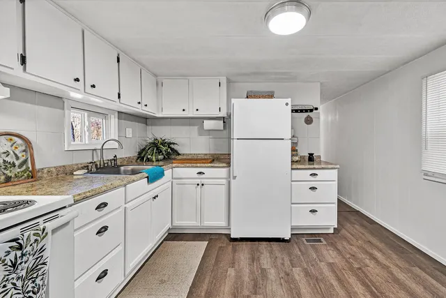 a kitchen with cabinets appliances a sink and a counter space
