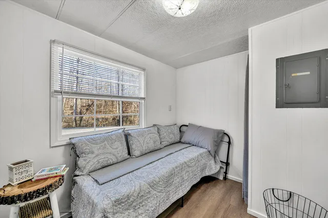 a bedroom with a bed and wooden floor