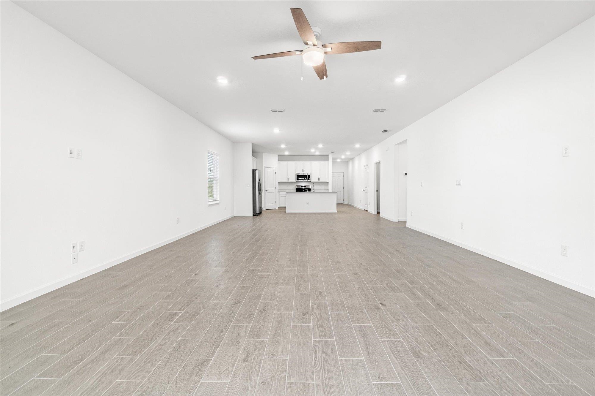 89 Kingsley Pk Way St. Augustine, FL 32084 - Photo 12 of 67 Unfurnished living room featuring ceiling fan, wood tiled floors, and recessed lighting
