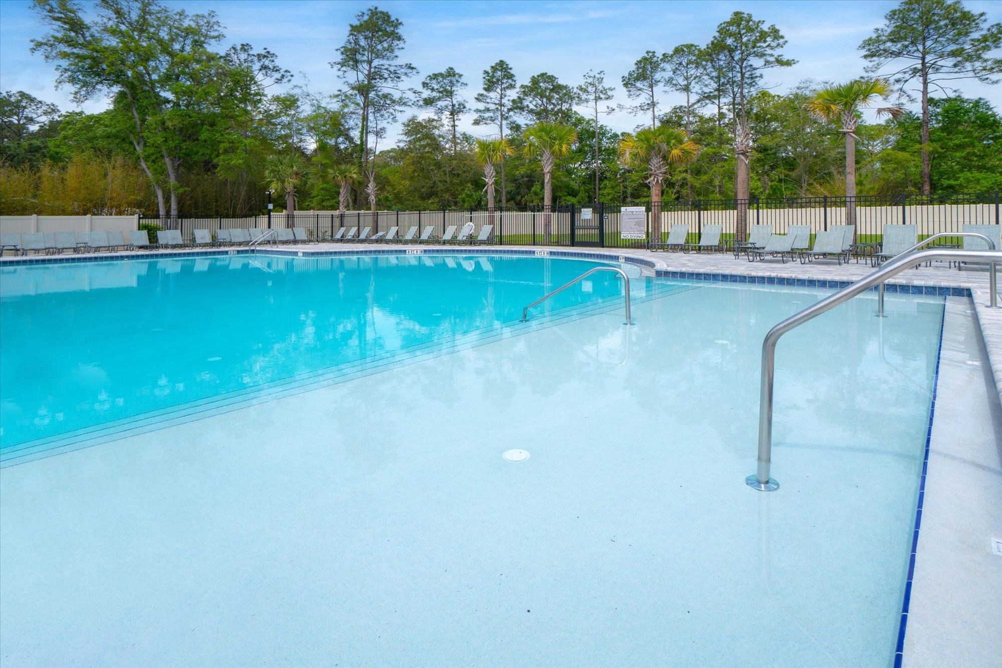 89 Kingsley Pk Way St. Augustine, FL 32084 - Photo 63 of 67 a view of a swimming pool with a patio and a yard with palm trees