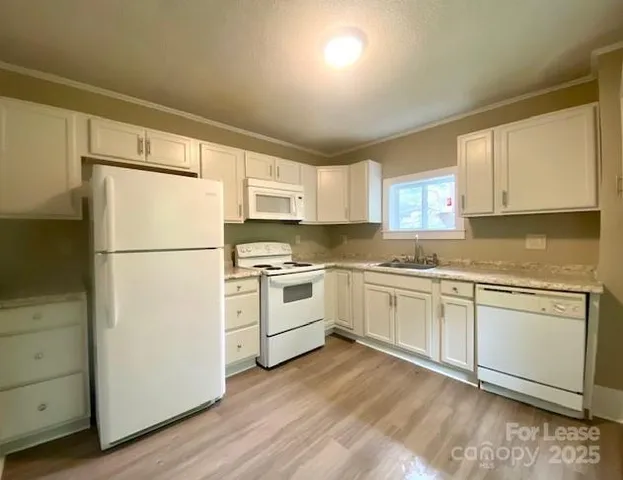a kitchen with white cabinets and white appliances
