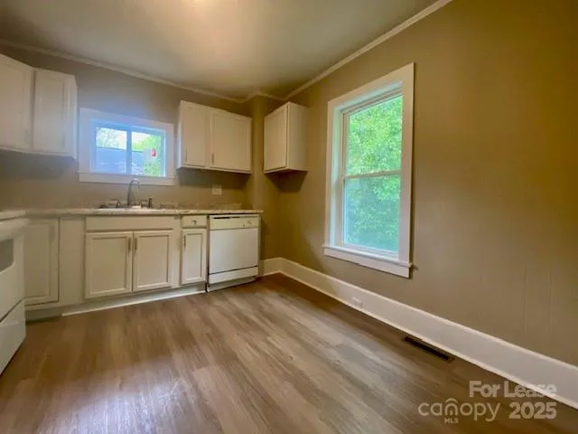 a kitchen with stainless steel appliances granite countertop a sink and cabinets with wooden floor