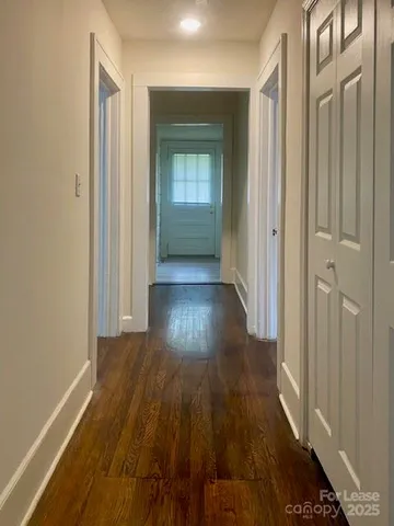 a view of a hallway with wooden floor
