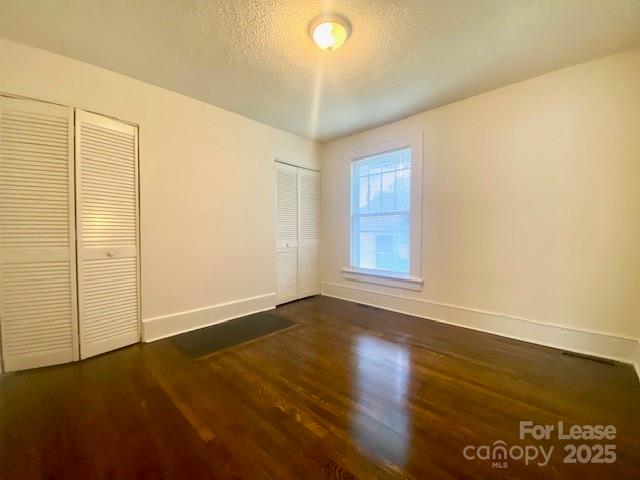 154 Franklin Avenue Northwest Concord, NC 28025 - Photo 10 of 14 an empty room with wooden floor and windows with curtains