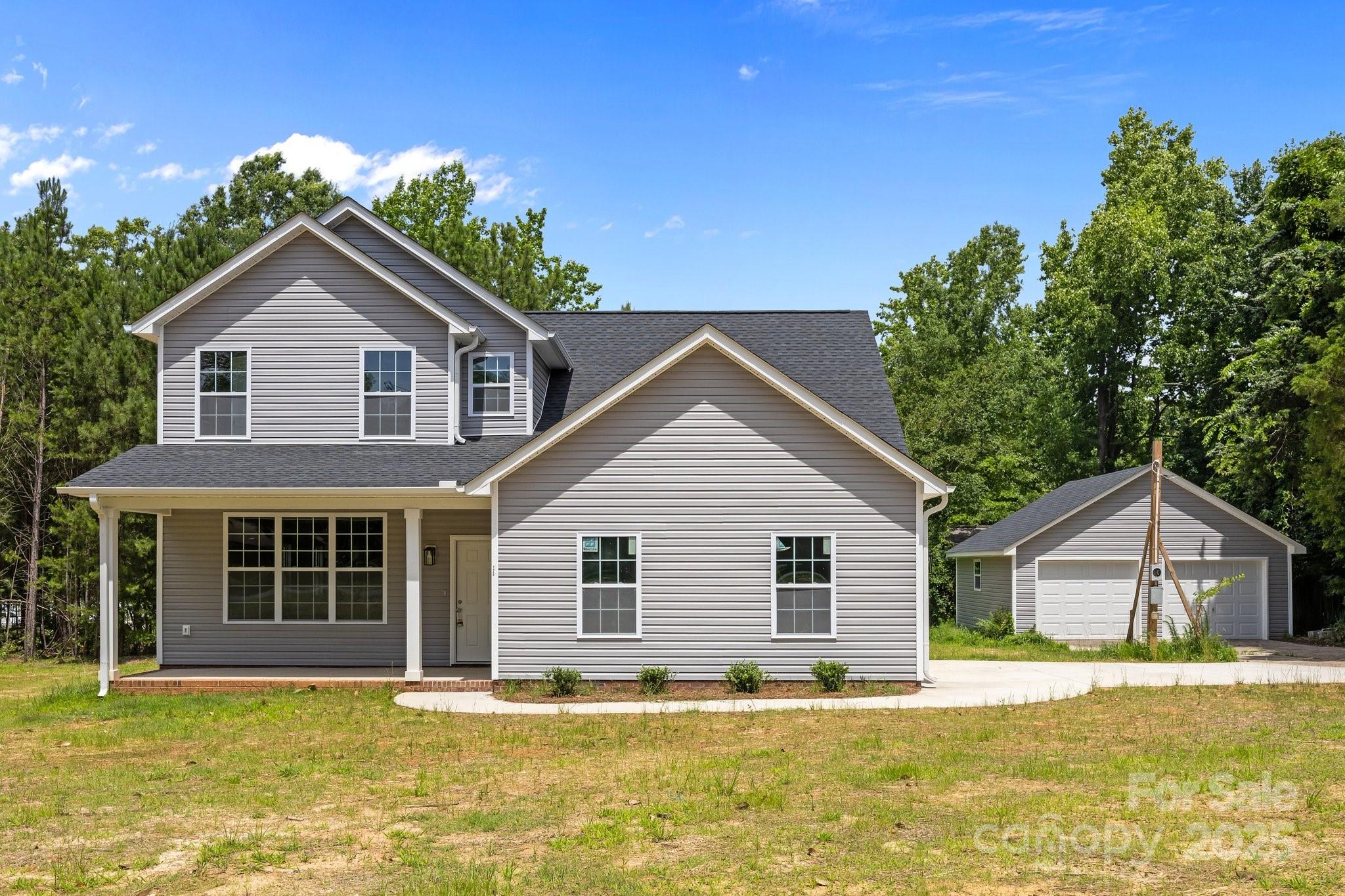 a front view of house with yard and trees in the background