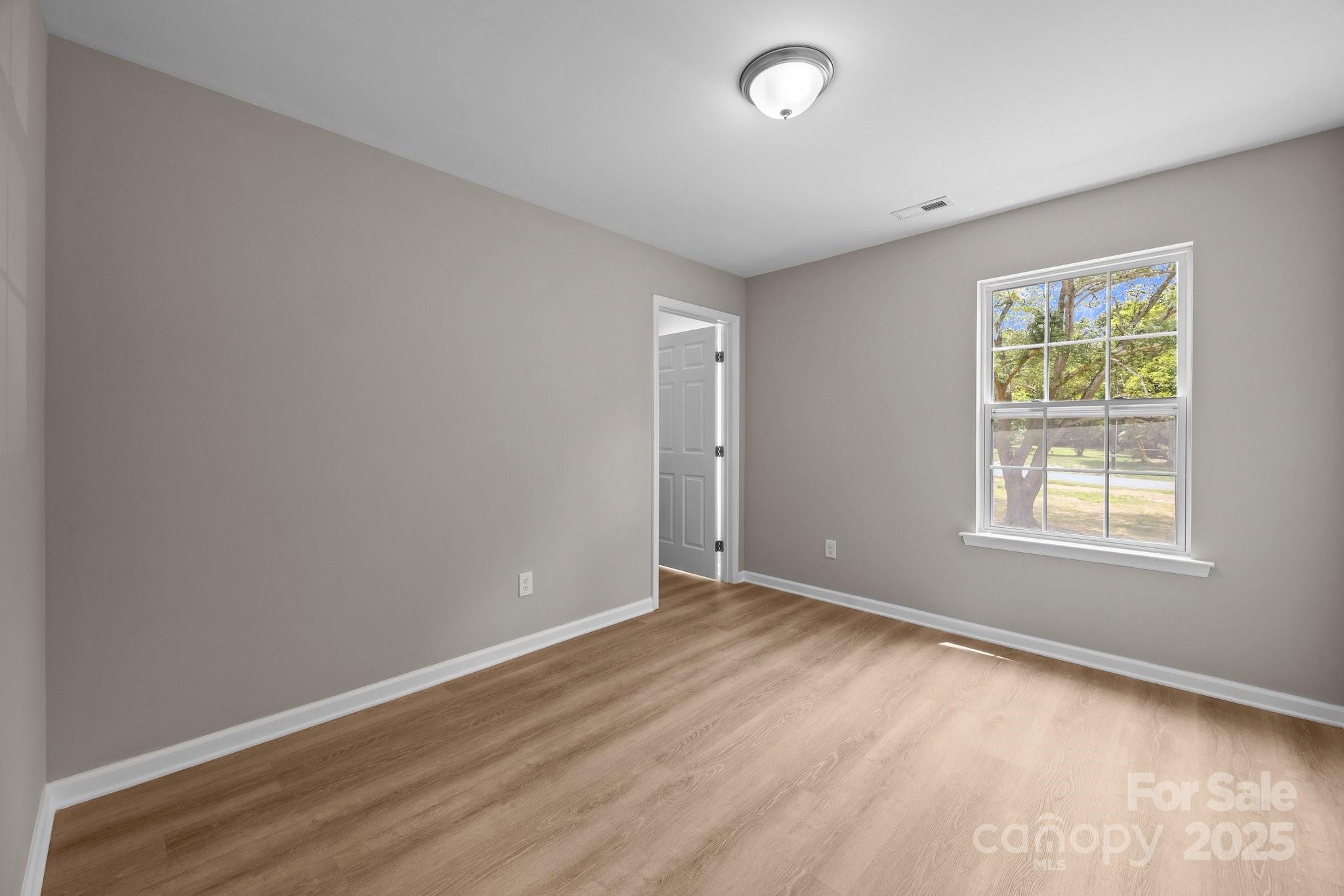 126 Aurora Boulevard Matthews, NC 28105 - Photo 20 of 41 an empty room with wooden floor and windows