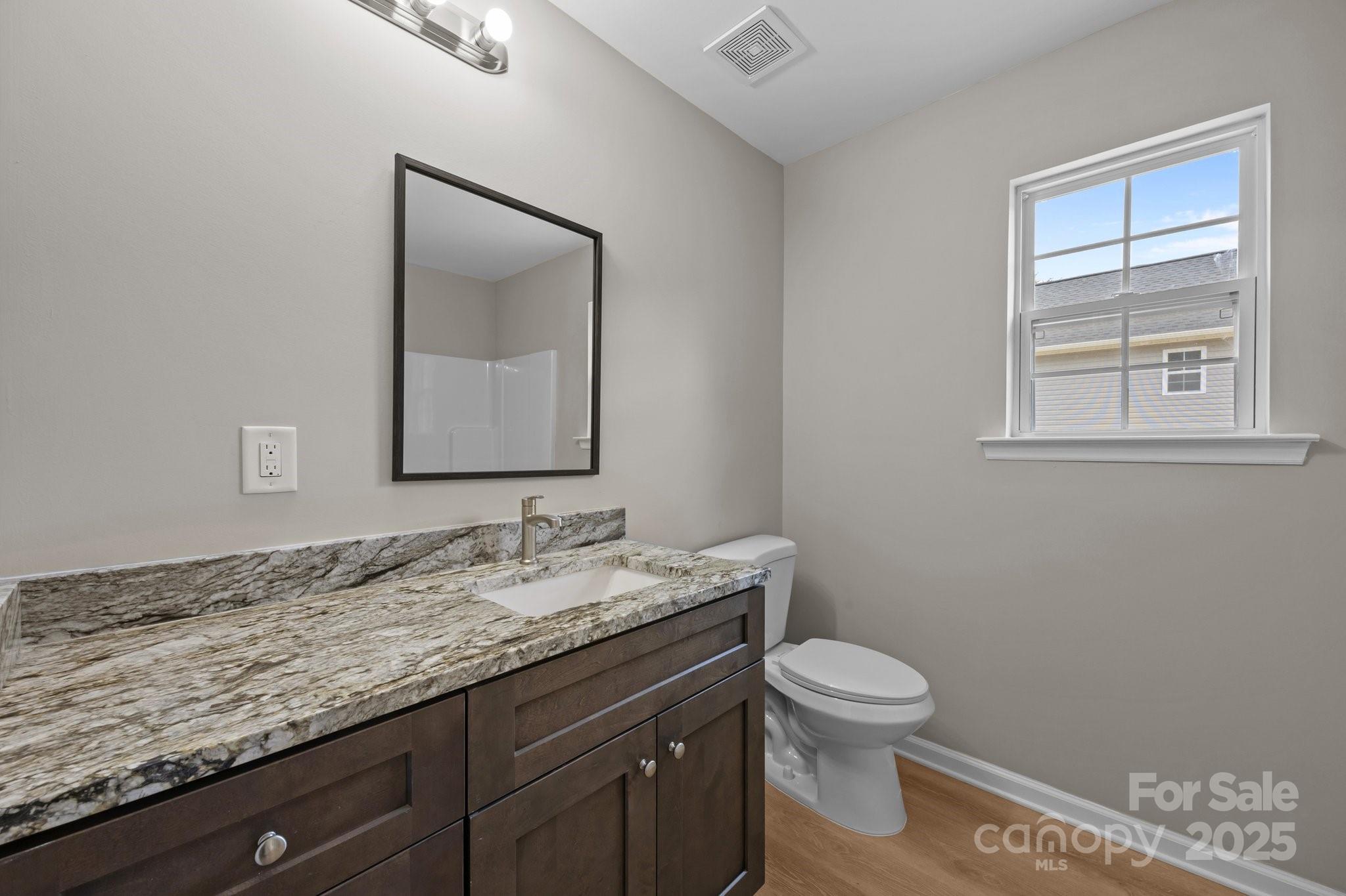 126 Aurora Boulevard Matthews, NC 28105 - Photo 23 of 41 a bathroom with a granite countertop toilet sink and mirror