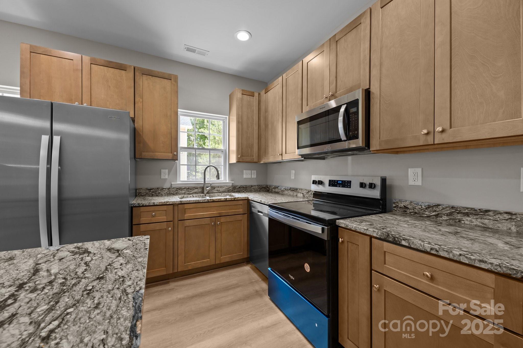 126 Aurora Boulevard Matthews, NC 28105 - Photo 10 of 41 a kitchen with granite countertop a refrigerator stove top oven and sink