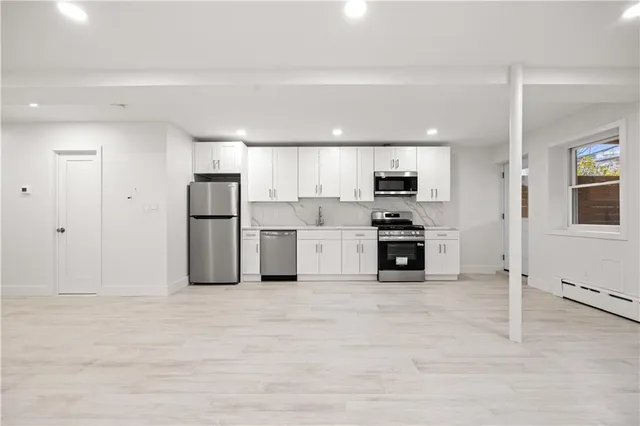 a kitchen with stainless steel appliances a refrigerator sink and cabinets