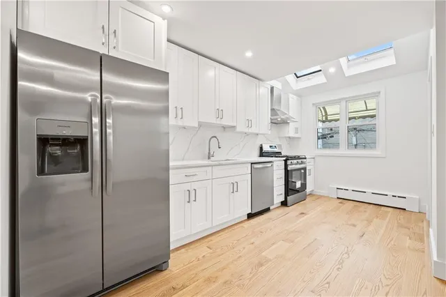 a kitchen with a refrigerator sink and cabinets