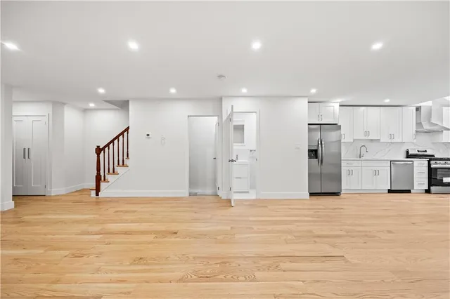 a view of a kitchen with a refrigerator and a stove top oven