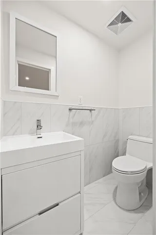 a bathroom with a sink mirror vanity and toilet