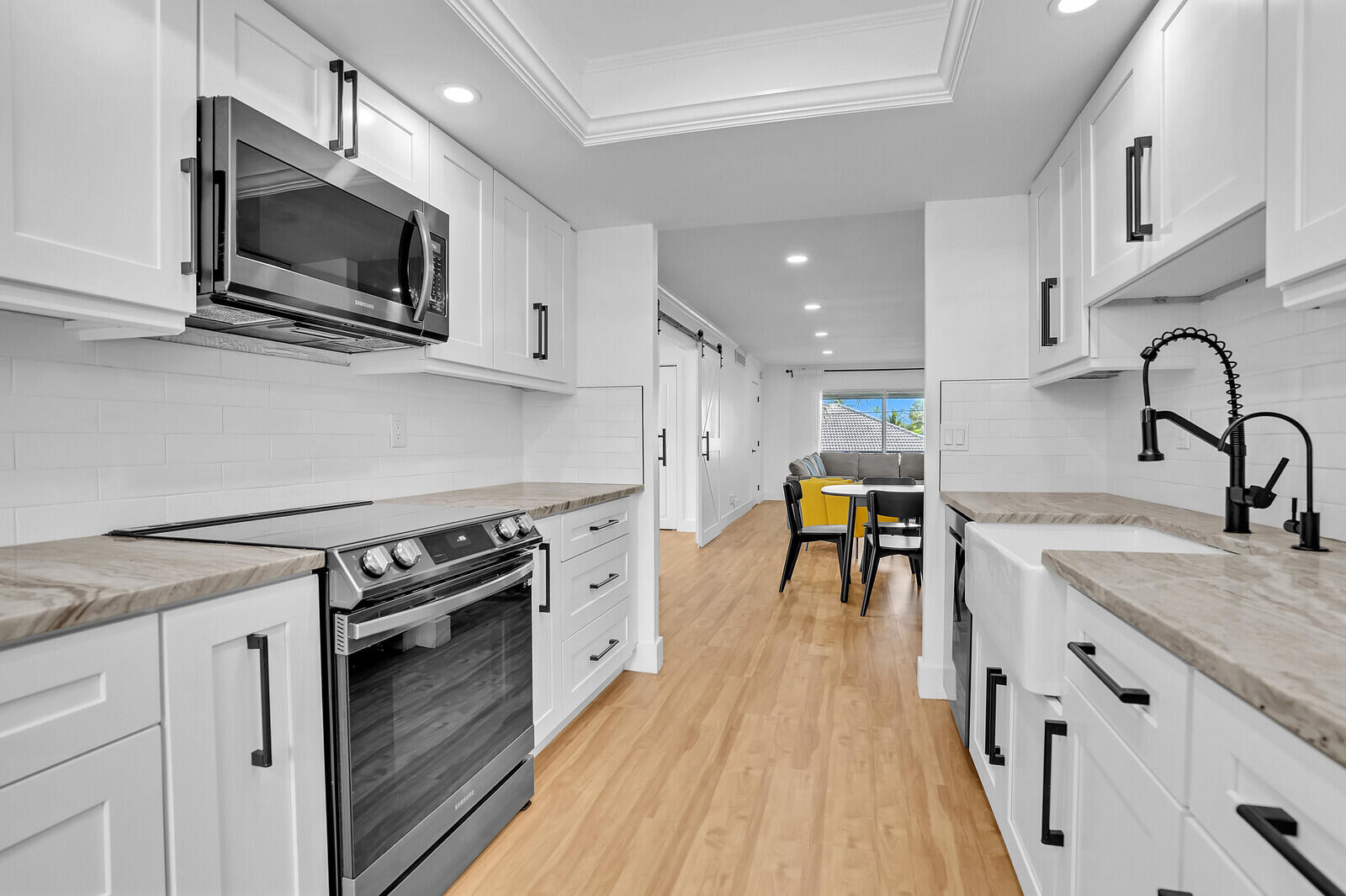 1210 Sugar Sands Boulevard, Unit 243 Singer Island, FL 33404 - Photo 22 of 55 a kitchen with stainless steel appliances granite countertop a stove a sink and a microwave