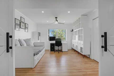 a view of a workspace with furniture and a window