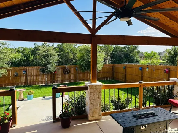 a view of a patio with table and chairs under an umbrella with a small yard